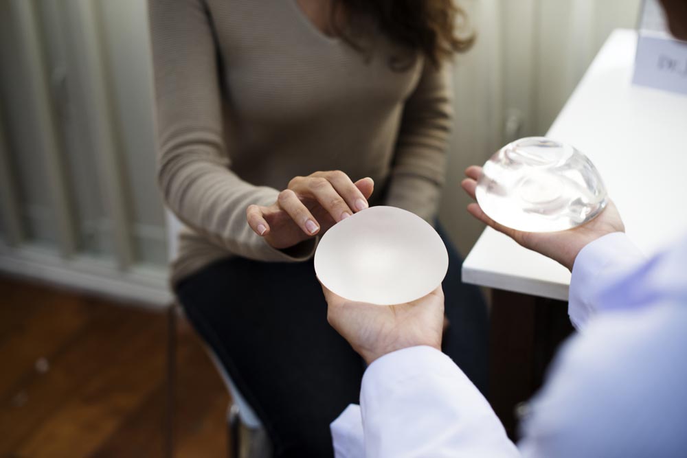 Kvinna som kollar på olika varianter av implantat